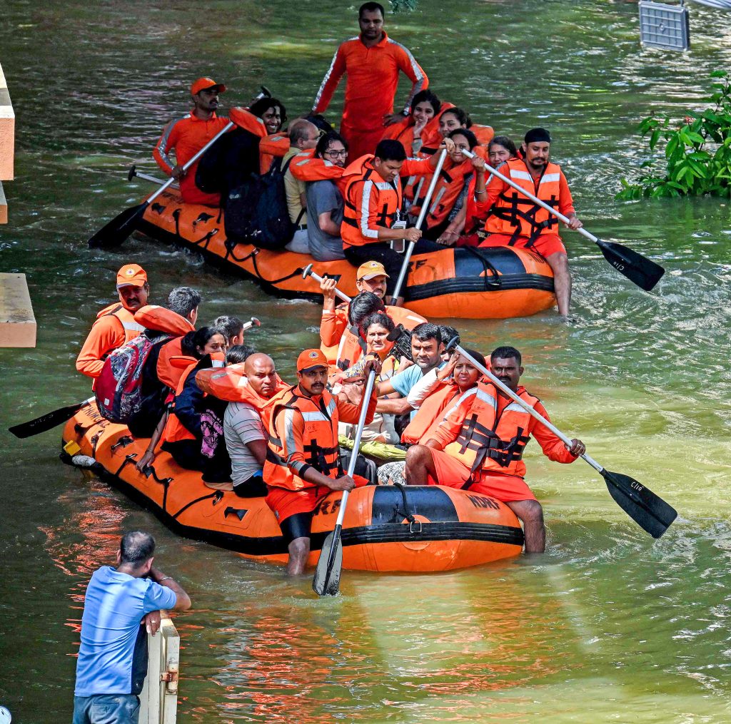 NDRF personnel evacuates the people from a flood-affected Kendriya Vihar apartment