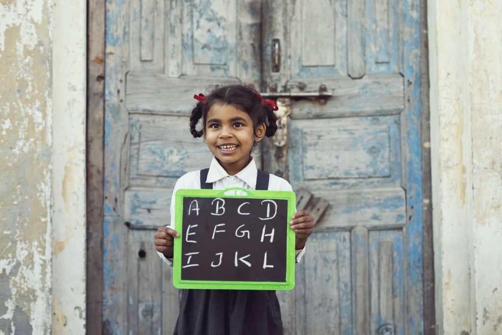 Little school girl holding slate