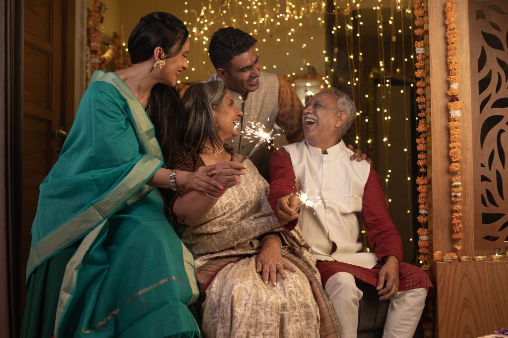 Two generation family burning sparklers at home during Diwali